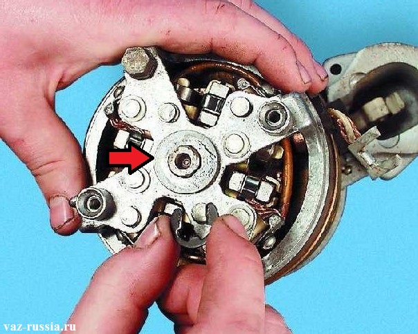 Снятие стопорного кольцо с центральной части электродвигателя, и после чего снятие шайбы которая указана стрелкой